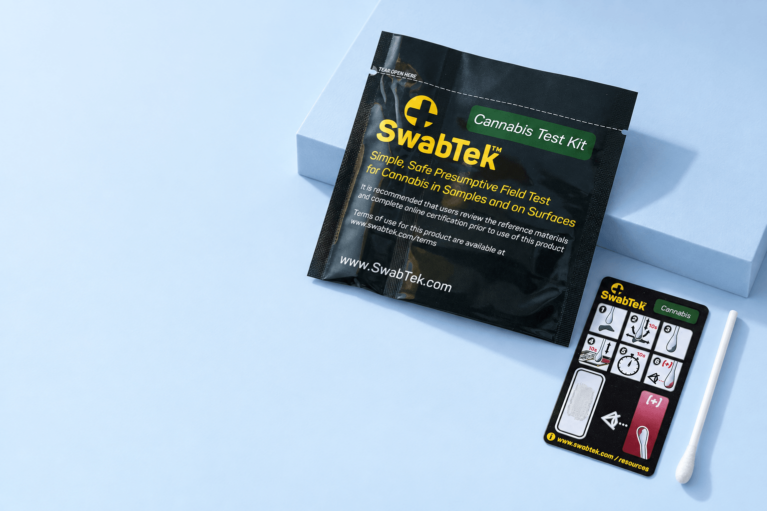 SwabTek Cannabis sachet, reference card and swab on a pale blue studio surface